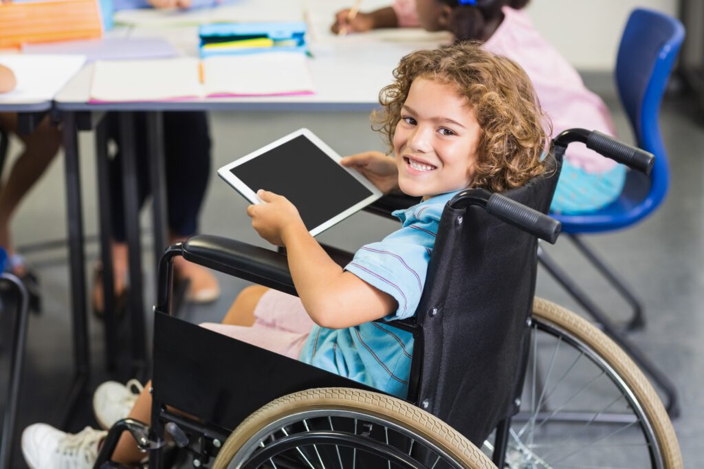 Portrait of disabled schoolboy using digital tablet